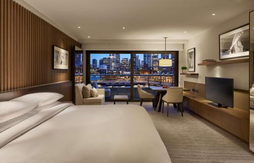 悉尼悉尼柏悦酒店的一间酒店客房,设有一张大床和一间用餐室