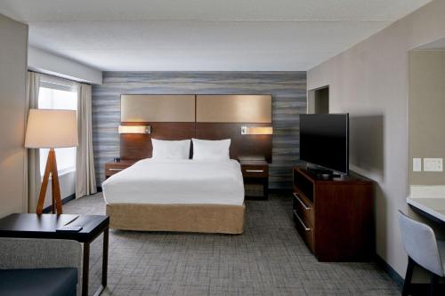 罗切斯特Residence Inn by Marriott Rochester West Greece的配有一张床和一台平面电视的酒店客房