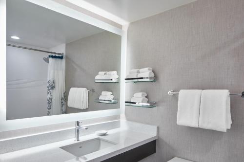 罗切斯特Residence Inn by Marriott Rochester West Greece的浴室配有盥洗盆、镜子和毛巾