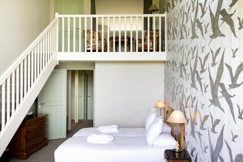 圣米歇尔山圣米歇尔驿站酒店的带床和楼梯的房间