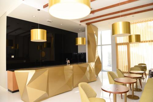 佩德拉斯萨尔加达斯Hotel Pedras Salgadas的餐厅设有金色柜台和桌椅