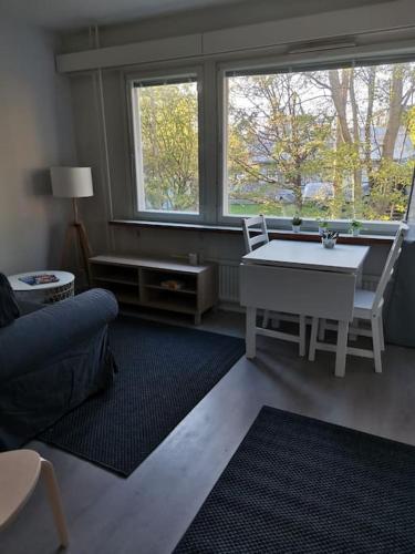 科科拉Ihana yksiö的客厅配有桌椅和窗户。