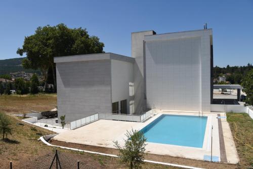 佩德拉斯萨尔加达斯Hotel Pedras Salgadas的一座房子前面设有游泳池