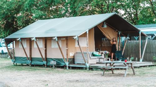 霍尔滕Glamping Holten luxe safaritent 2的站在帐篷内的女人