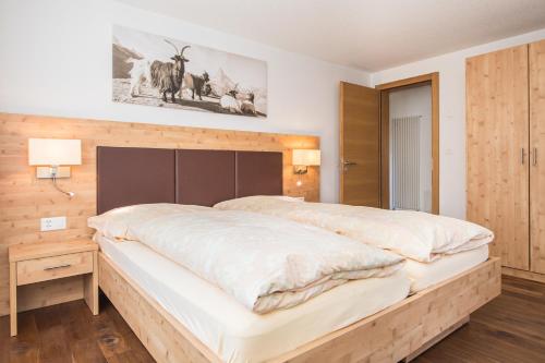 采尔马特菲利斯度假别墅酒店的一间卧室配有一张大床和木制床头板