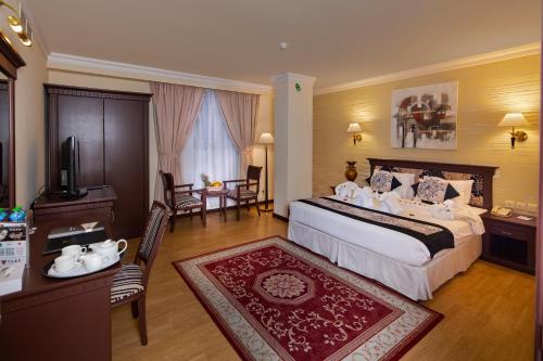 麦纳麦帕尔斯国际大酒店的酒店客房带一张床、一张桌子和椅子