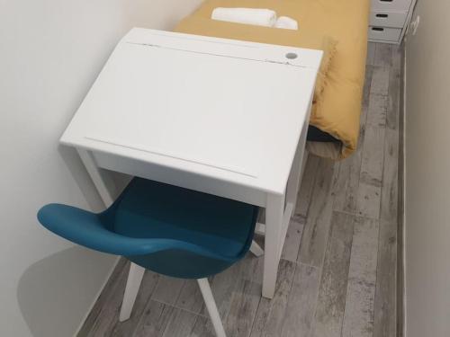 奥尔日河畔布雷蒂尼L'art et Deco RerC-n104-A6-A10的一张白色的桌子,旁边是蓝色的椅子