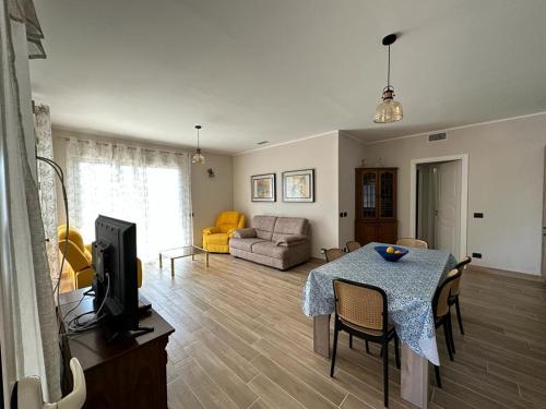 切法卢Villa Valentina的客厅配有桌子、电视和沙发。
