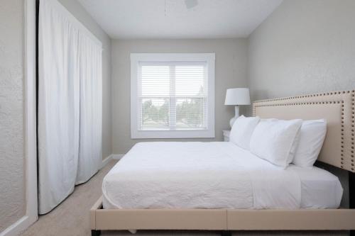 阿马里洛Dragon on Taylor St的白色的卧室设有白色的床和窗户。