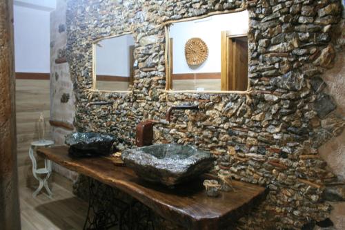 贝尔韦代雷Il Podere dell'Angelo的石质浴室设有水槽和镜子
