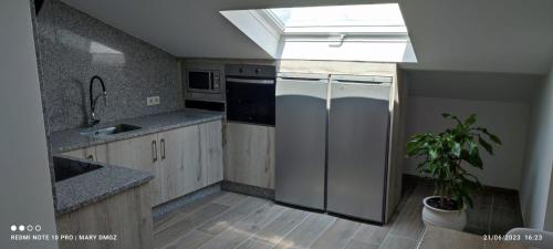 格罗韦碧丽莎德玛酒店的厨房配有不锈钢冰箱和天窗