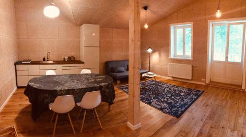 恩古雷Pērlerada room的配有桌椅和厨房的房间