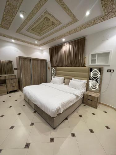 欧拉Friday Suites的一间卧室设有一张大床和格子天花板