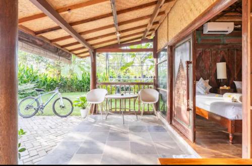 吉利阿尔Al-Shifa Healing House Lombok的卧室配有一张床和一张桌子及椅子