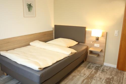 奥斯特菲尔登Kemnater Hof Apartments的一张床上有两个枕头的房间