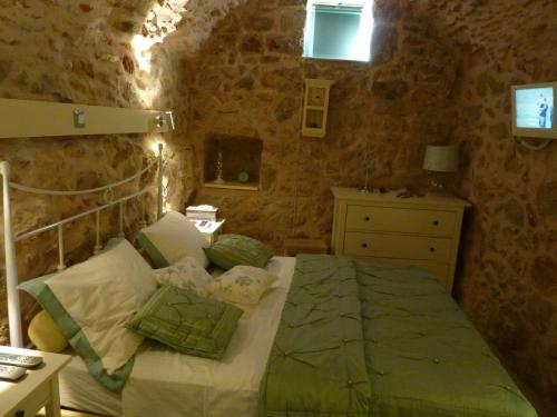 Ágios Geórgios Sykoúsis圣乔治斯考西斯传统住宅度假屋的卧室配有一张石墙床