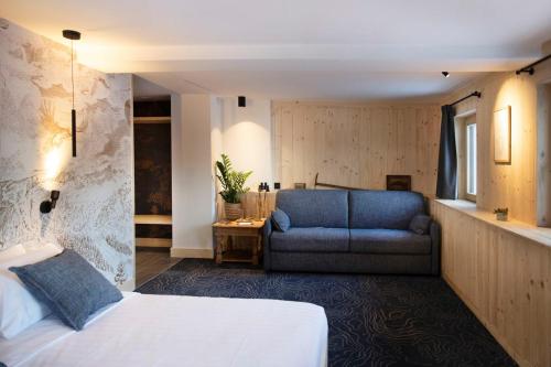格里翁Miroir d'Argentine的一间卧室配有一张床和一张蓝色的沙发
