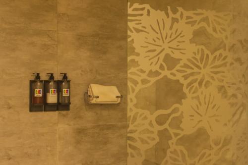 罗萨里奥1412精品酒店 的浴室墙上有三瓶肥皂