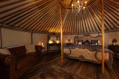 林肯Lincoln Yurts的蒙古包内一间卧室配有一张床和一张沙发