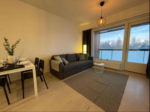 海门林纳Kaksio keskustassa ja rannan läheisyydessä的客厅配有沙发和桌子