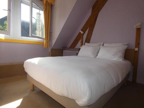 蓬莱韦克Hôtel de France的卧室配有一张白色大床和两个窗户