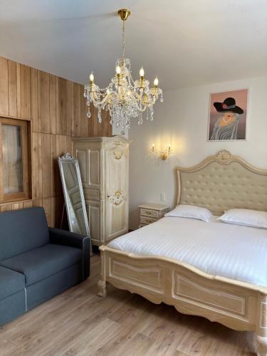 纳博讷Studio familial Maison de L'église du Couvent的一间卧室配有一张床、一把椅子和一个吊灯。