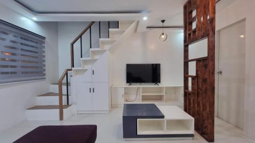 武端市Brand New Camella 2 Bedroom House的一间带楼梯和电视的客厅