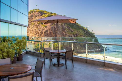里约热内卢勒梅竞技场酒店 的俯瞰大海的阳台的桌子和遮阳伞