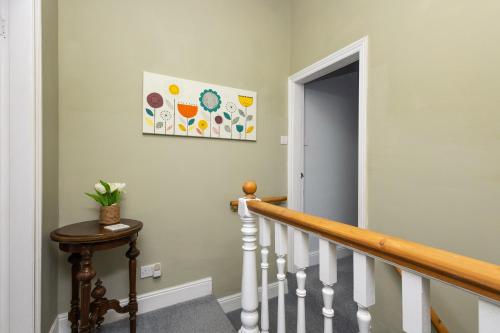 HorburyHorbury High St Wakefield的走廊上设有楼梯,墙上挂有绘画作品
