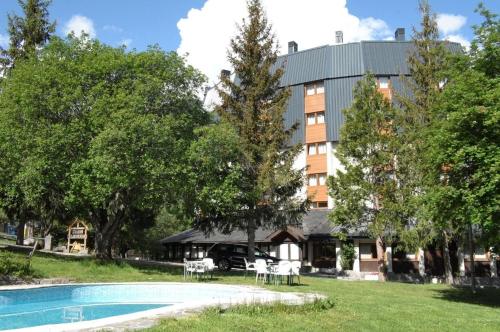 埃斯波特Hotel Or Blanc的一座带游泳池的度假村,位于一座建筑前