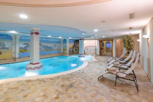科戈洛多米纳帕尔科德罗斯泰尔维奥酒店的一个带椅子的房间的游泳池
