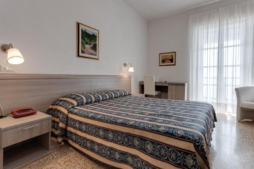 瓦隆布罗萨瓦隆布罗萨格兰德酒店的配有一张床和一把椅子的酒店客房