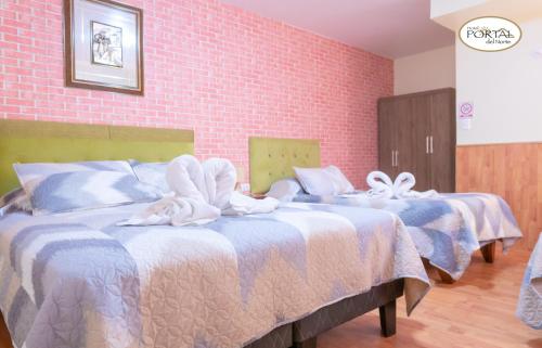 科皮亚波Hotel Portal del Norte的两张位于酒店客房的床,配有毛巾