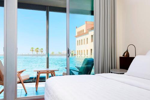 埃勒凡达尔艾美海滩水疗酒店的一间卧室配有一张床,享有水景