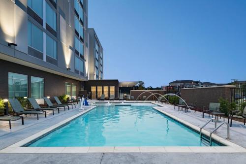 达拉斯SpringHill Suites by Marriott Dallas Richardson/University Area的一座带椅子的游泳池以及一座建筑