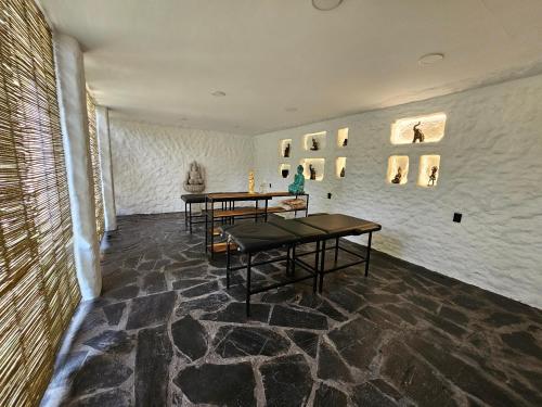 迪坡斯特兰CASA NDOMI TEPOZ的一间设有两张桌子的房间和一幅画作的墙壁