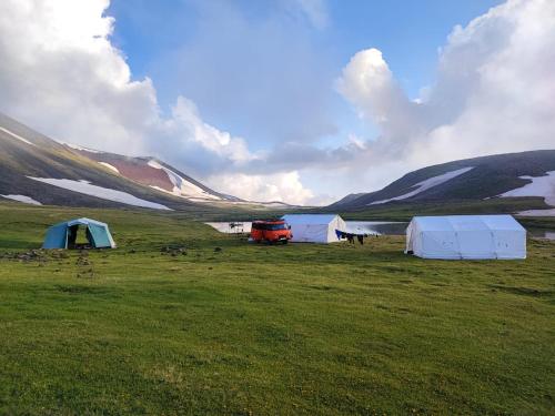 埃里温Highland Hostel的一群帐篷位于湖边的田野