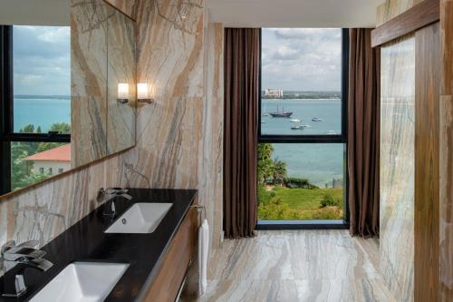 达累斯萨拉姆Element by Westin Hotel Dar es Salaam的一间带两个盥洗盆的浴室和一个大窗户