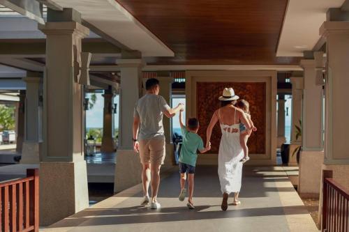 奈扬海滩Phuket Marriott Resort and Spa, Nai Yang Beach的走在房子走廊上的家庭