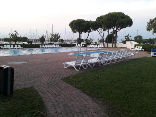 阿普里利亚马利蒂马Boat House Alena的游泳池旁的一排白色椅子