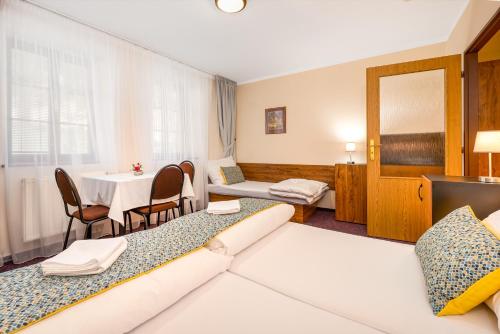 Zlatá Koruna坎普克朗膳食公寓酒店的酒店客房设有两张床和一张桌子。