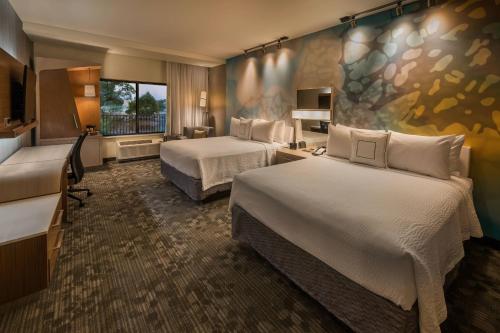 里诺里诺市中心/河滨万怡酒店的酒店客房设有两张床和窗户。