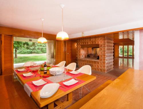 特雷维索Villa di design con grande parco的一间带桌椅和壁炉的用餐室
