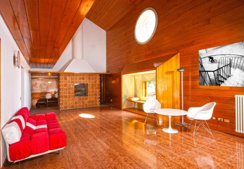 特雷维索Villa di design con grande parco的客厅配有红色的沙发和桌子