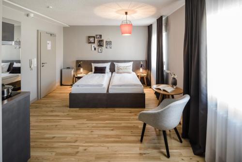 美因河畔法兰克福Bold Hotel Frankfurt Messe的一间卧室配有一张床、一张桌子和一把椅子