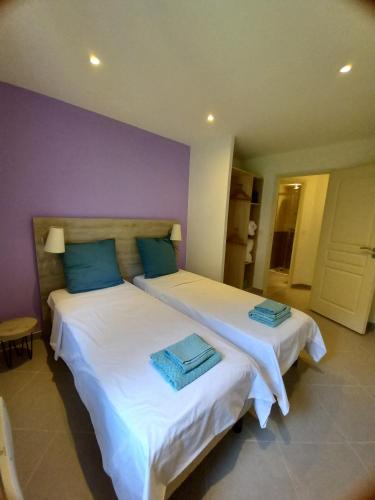 PierlasGITES DE PIERLAS的一间卧室配有两张带蓝色枕头的床