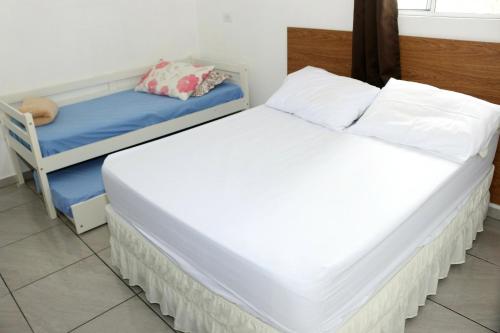 弗洛里亚诺波利斯Pousada Decarli Executiva Aeroporto Florianópolis的配有两张单人床的房间,设有一张床和一把椅子