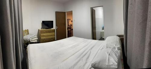 圣贝纳迪诺Casa en San Bernardino Py的卧室配有白色的床和镜子