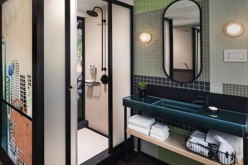 纽约Moxy NYC East Village的浴室设有蓝色水槽和镜子