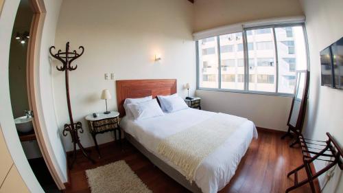 利马Atrium Miraflores Hotel的卧室配有白色的床和窗户。